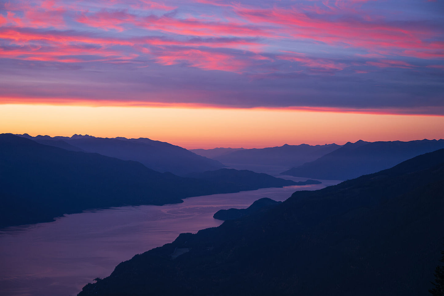 A colorful sunrise over Kootenay Lake with mountains in the background, as seen from Buchanan Peak, West Kootenay fine art print by Ashley Voykin