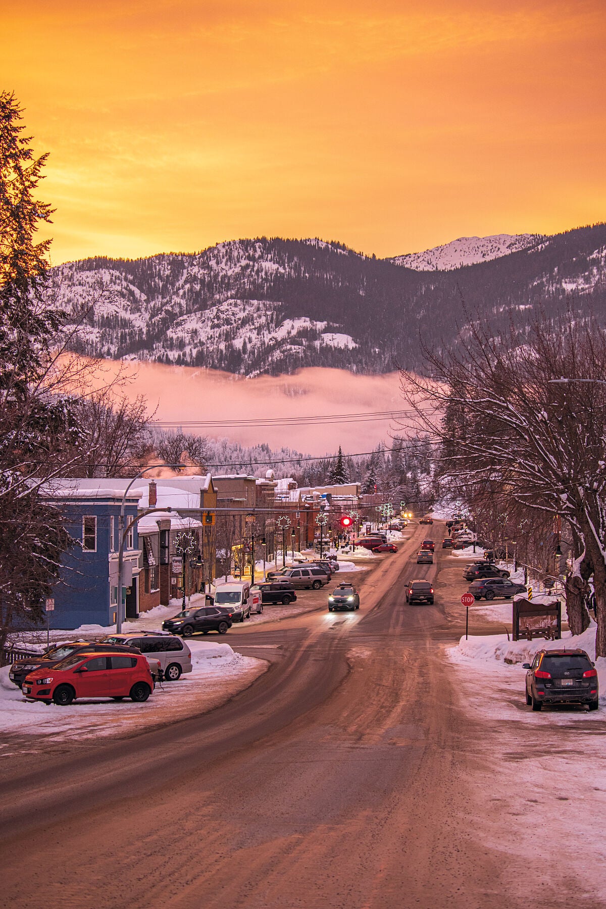 A vibrant winter sunset over downtown Rossland, in the Columbia Basin of British Columbia. Landscape photography by Ashley Voykin.