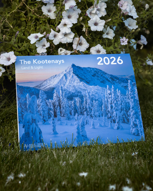 2026 calendar for The Kootenays with mountain and landscape design on grass with flowers.