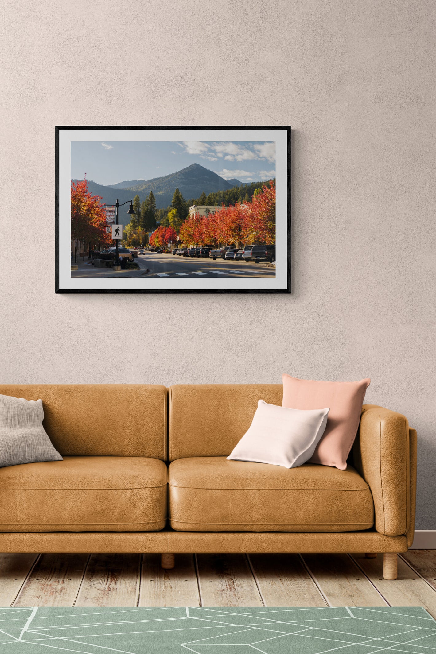 Framed photograph of Rossland, British Columbia on a wall in front of a couch.