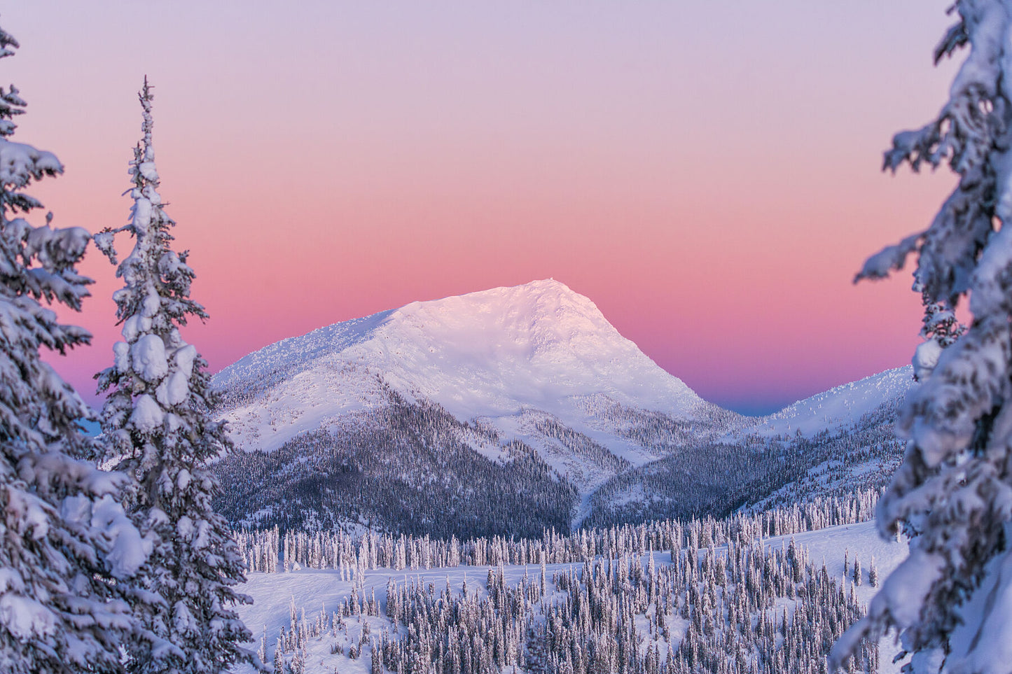 The first light of dawn on Old Glory Peak and RED Mountain resort in the winter season, fine art mountain photography by Ashley Voykin