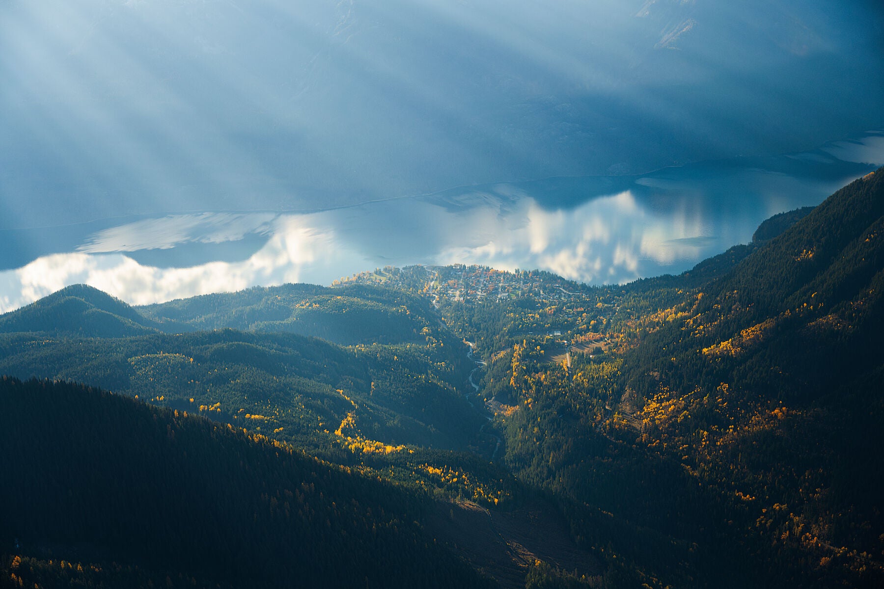 An aerial view of New Denver, British Columbia, with mountains and Slocan Lake, fine art landscape print from British Columbia’s West Kootenay region by Ashley Voykin