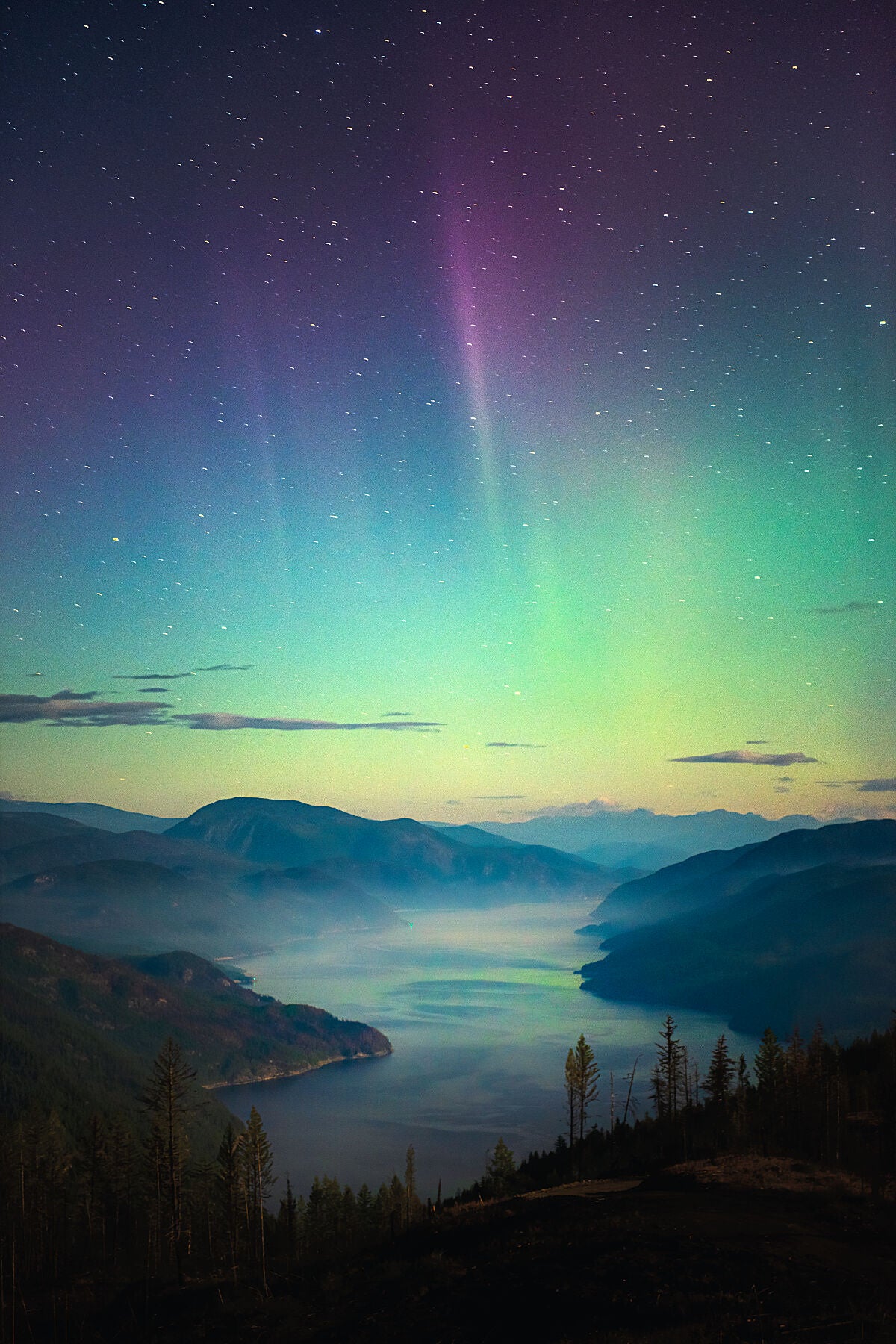 Aurora Borealis dancing above Lower Arrow Lake near Castlegar, in British Columbia’s Kootenay region, fine art photography by Ashley Voykin.