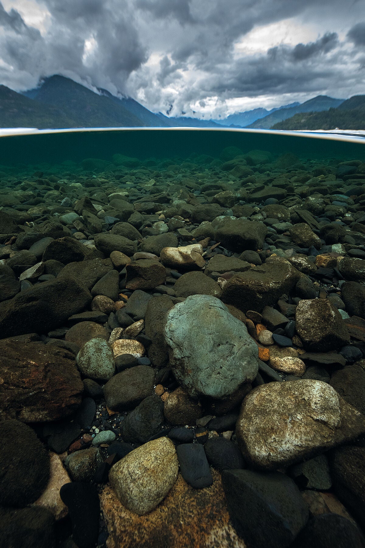 Slocan Lake underwater during a cloudy day, in British Columbia’s Kootenay region, fine art photography by Ashley Voykin.