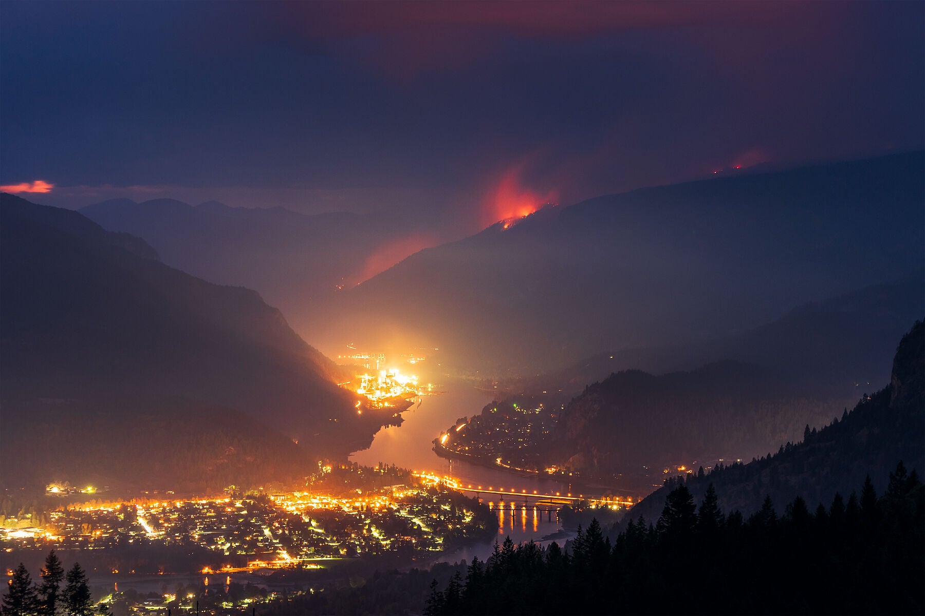 A nighttime view of the Syringa Creek Wildfire burning above Castlegar, in British Columbia's West Kootenay Region, Environment fine art landscape by Ashley Voykin