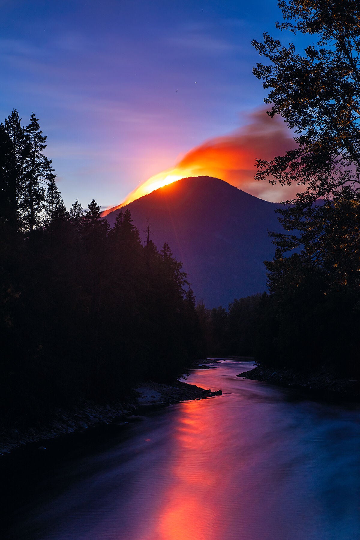 The Talbot Creek Wildfire reflected onto the Slocan River at Night, in the Slocan Valley, Environment photography by Ashley Voykin.