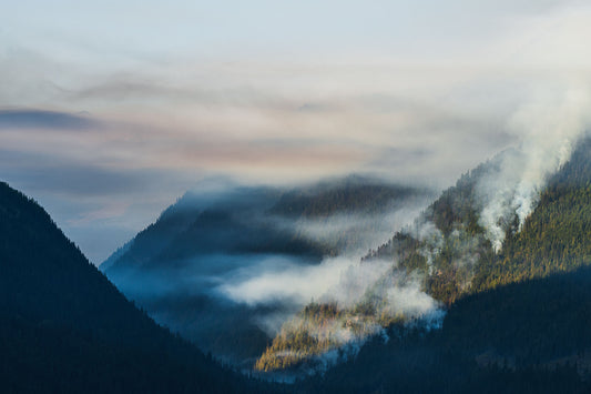 Smoke from the Glacier Creek Wildfire rises up into the air, in the Purcell Mountains of British Columbia. Environment fine art photography by Ashley Voykin