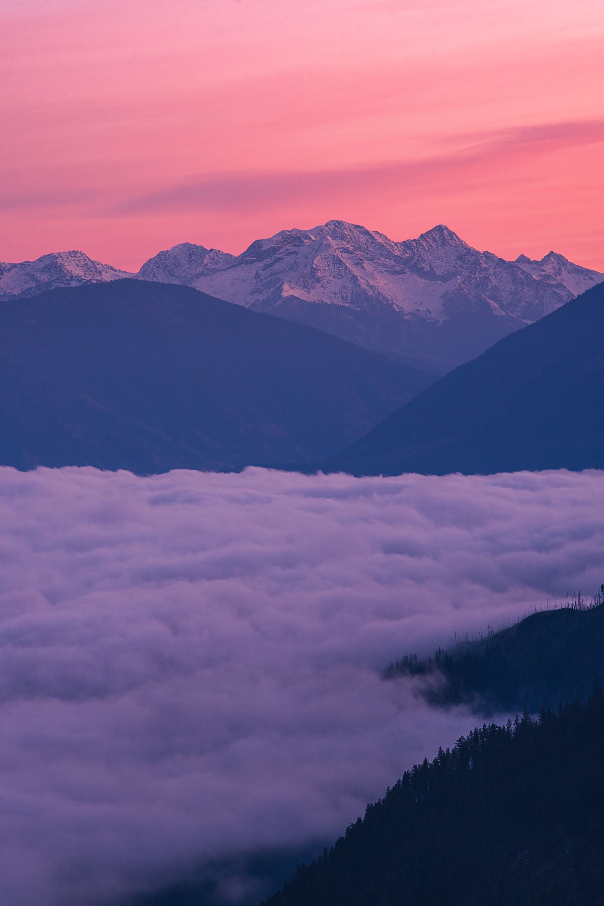 Pink sunrise on the peaks of the Goat Range, in British Columbia's Slocan Valley area. Fine art landscape photograph by Ashley Voykin.