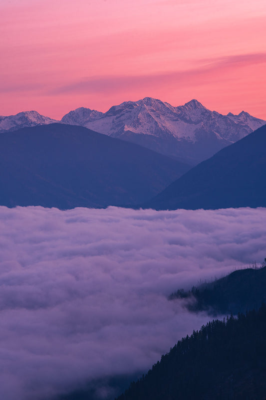 Pink sunrise on the peaks of the Goat Range, in British Columbia's Slocan Valley area. Fine art landscape photograph by Ashley Voykin.