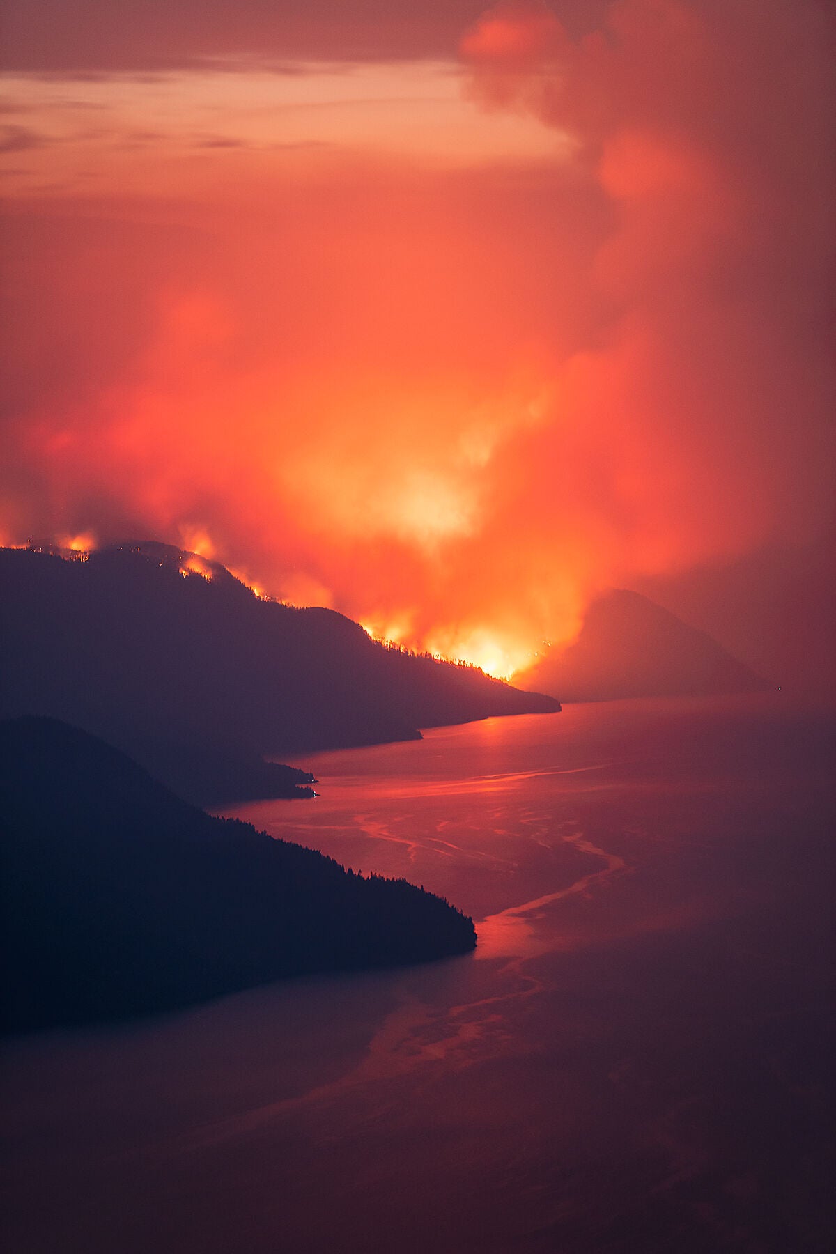 Michaud Creek Wildfire burning on Lower Arrow Lake, in the Monashee Mountains. Environment landscape photography by Ashley Voykin.