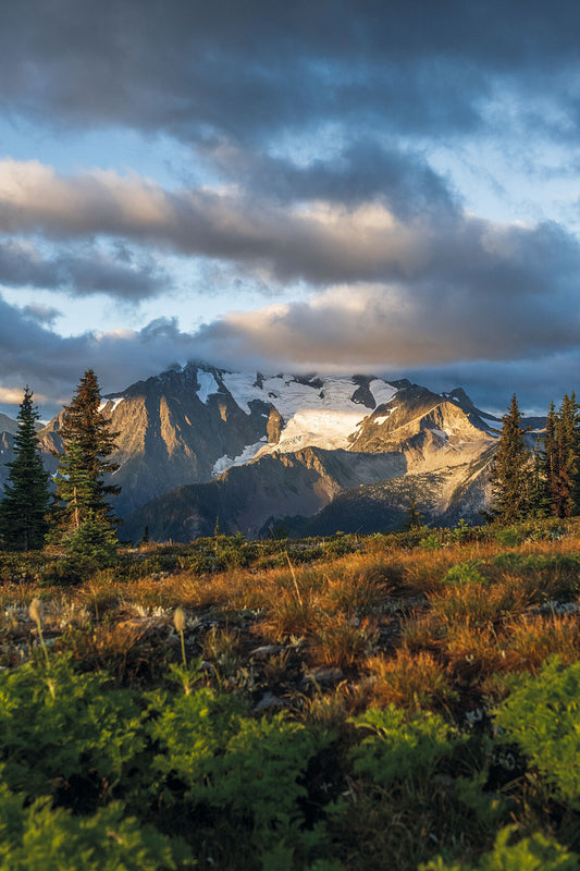 A photograph featuring the Spokane Glacier in the Goat Range of British Columbia, capturing the landscape at sunrise with a cloudy sky. By photographer Ashley Voykin in the West Kootenays